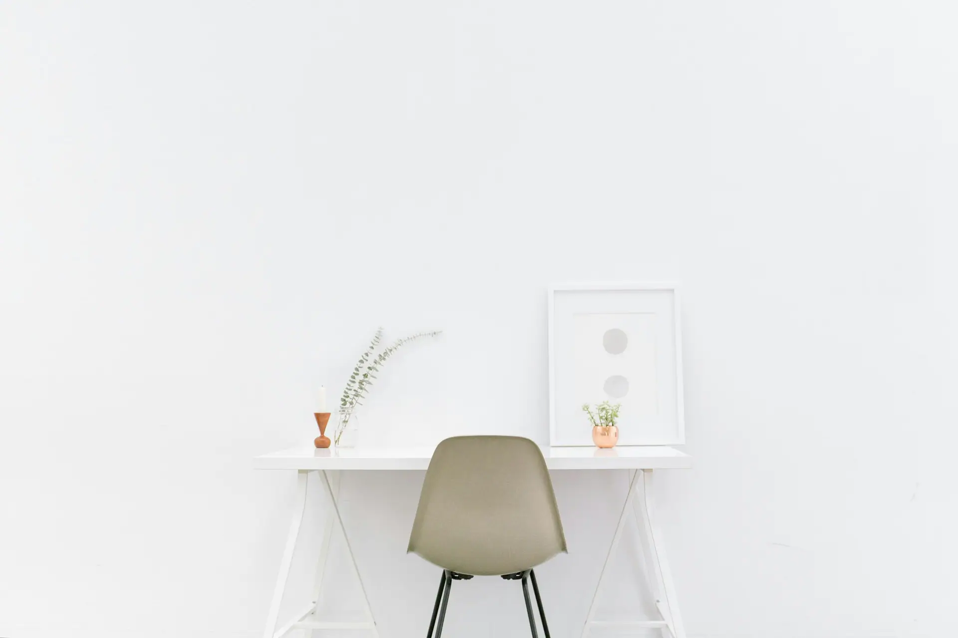 A minimalist design workspace with a clean desk and warm natural light.