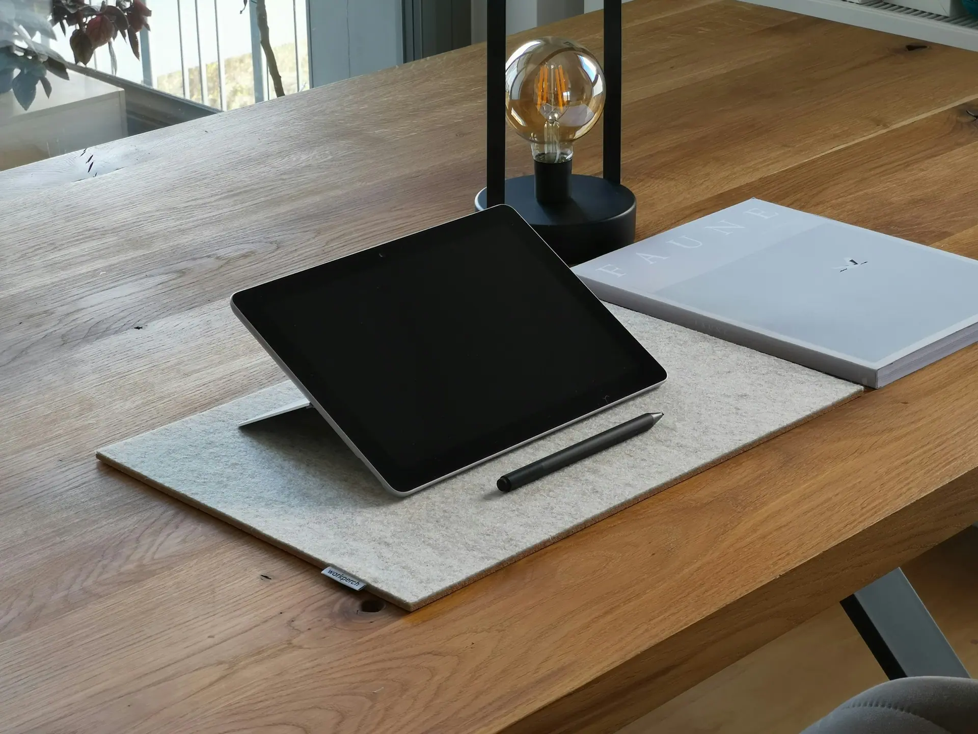 A presentation document on a desk styled with neutral materials.